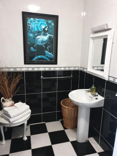 香农河畔卡里克Hillside Residence的黑白浴室设有水槽和镜子
