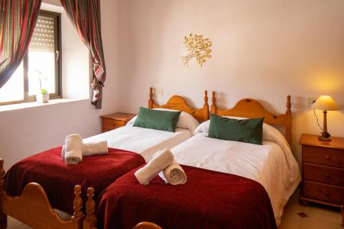 塞特尼尔La Casa de la Lela的一间卧室配有两张带毛巾的床