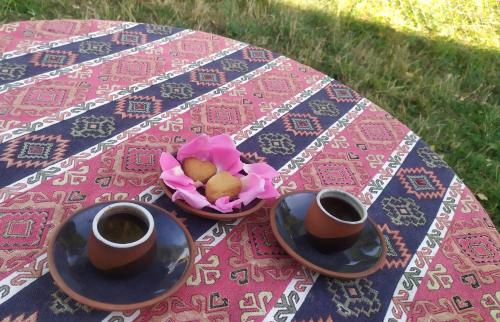 TandzatapʼSaro B&B的桌上放两杯咖啡和一碗鲜花
