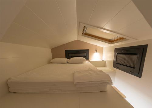 塞里克Efe Tiny House的卧室配有白色的床和窗户。