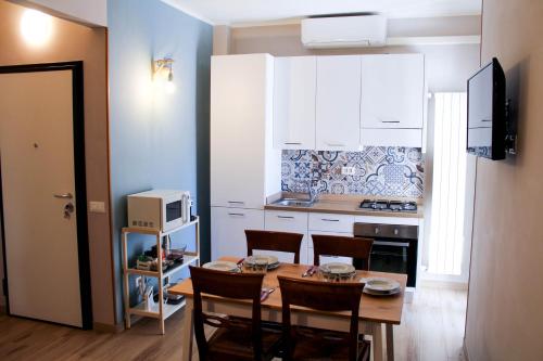 马瑞纳迪卡拉拉La Stella di Via Venezia的一间带桌椅的厨房和一间带白色橱柜的厨房
