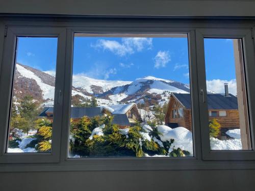 圣卡洛斯-德巴里洛切Catedral Sur departamento en Bariloche的享有白雪 ⁇ 山景的窗户