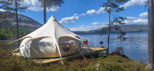 HauggrendTelemark Camping的坐在湖面上的一个码头上的白色帐篷