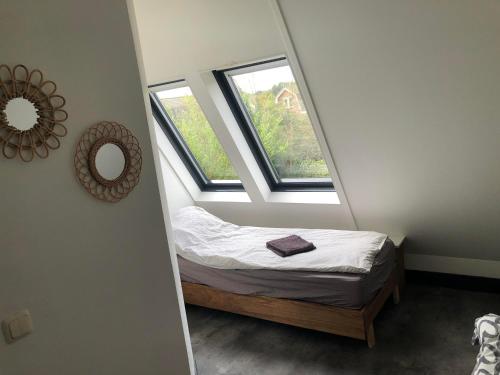 海滨诺德韦克Holiday Home de witte raaf with garden and hottub的一间小卧室,配有床和2个窗户