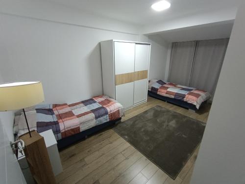 斯特鲁米察Grand Apartments Strumica的一间带两张床和橱柜的小卧室