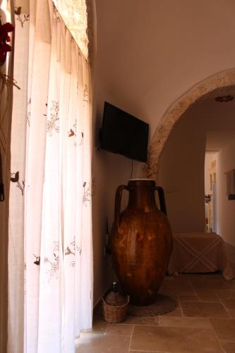 奥斯图尼Trullo Il Melograno的一个大花瓶,坐在一个窗户的房间