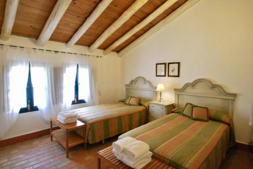 ZufreFinca La Vicaria AGUADULCE的一间卧室设有两张床和窗户。