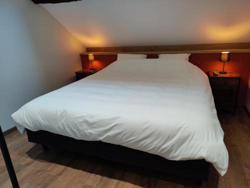 罗什福尔Le Saint Michel的一间卧室配有一张带白色床单和两盏灯的床。