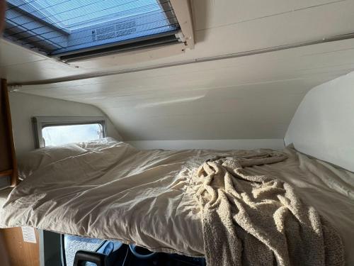 凯夫拉维克Camping Van的一个小房间的一个床位,设有窗户