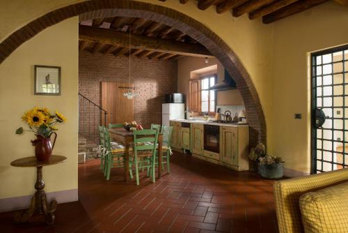 圣吉米纳诺Il Coltro的厨房设有拱门和桌椅