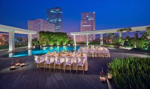 雅加达Mandarin Oriental, Jakarta的一个带桌椅的宴会区和游泳池