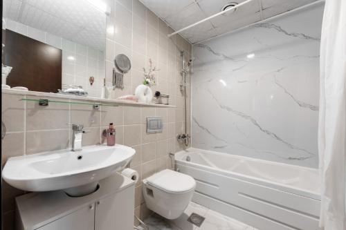 迪拜Great Gatsby's Home的浴室配有盥洗盆、卫生间和浴缸。