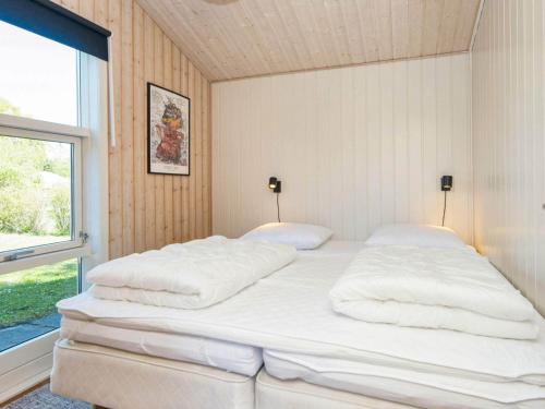 格莱斯堡10 person holiday home in Glesborg的窗户客房内的一张大白色床