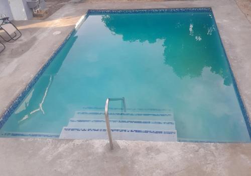 蒙特哥贝Oak Villa Montego Bay 2的蓝色海水游泳池,里面设有楼梯