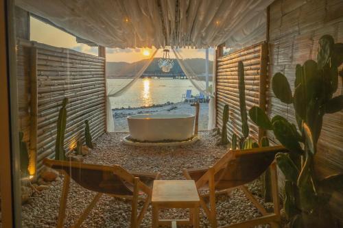 格兰岛Bamboo Beachfront Koh Larn的带浴缸、两把椅子和一张桌子的房间