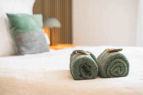 斯图加特TheServiced - Design Apartments的几条绿毛巾坐在床上