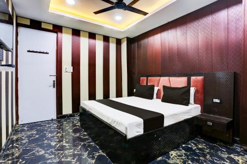 坎普尔OYO Flagship Shri Govindam palace的一间卧室设有一张带木墙的大床