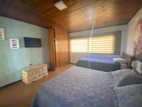 埃尔基斯科Habitaciones Mar Azul的一间卧室配有两张床和电视。