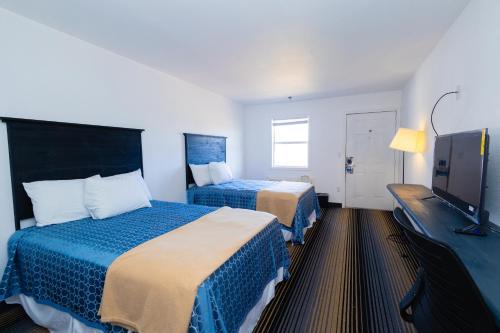 Brookshire布鲁克酒店 的酒店客房设有两张床和一台平面电视。