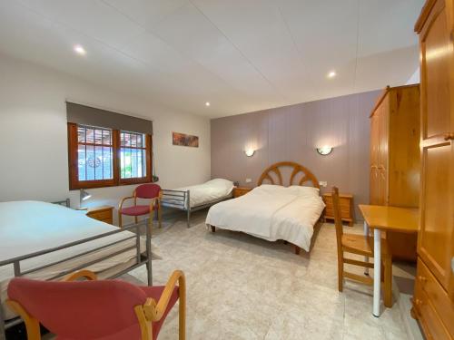 比德雷雷斯Club Villamar - Iako的一间卧室配有两张床和一张桌子及椅子