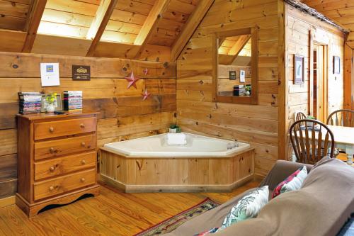 加特林堡Cozy Cabin! Hot Tub, King Bed, Fireplace, & Pool的木制客房内的带浴缸的浴室