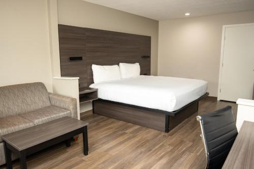 哈灵根哈林根美国最佳价值旅馆的一间卧室配有一张床、一张沙发和一把椅子