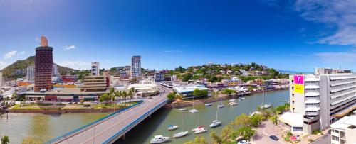 汤斯维尔Oaks Townsville Gateway Suites的河里有桥梁和船只的城市