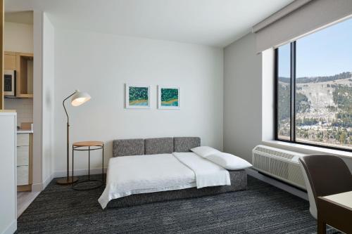 埃文TownePlace Suites by Marriott Avon Vail Valley的一间卧室设有一张床和一个大窗户