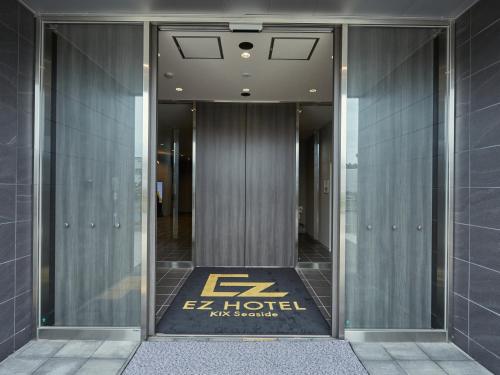 泉佐野EZ HOTEL 関西空港 Seaside的门上标有标志的酒店入口