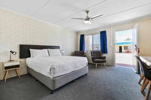 赫维湾赫维主湾康夫特汽车旅馆的卧室配有一张床和一张桌子及椅子