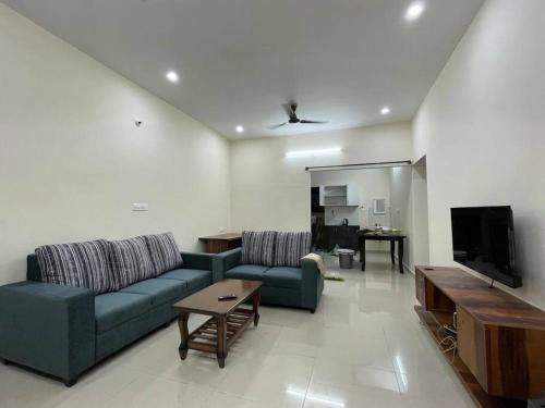 班加罗尔SSN Home Stays in Bangalore near PLAY Arena的带沙发和电视的客厅