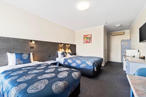 科拉克Colac Central Motel的酒店客房配有两张床和一张书桌