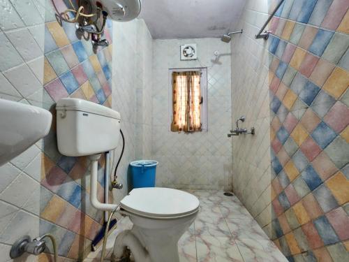 西姆拉Hotel Tirupati Regency Anandam的一间带卫生间和马赛克墙的浴室