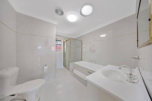 NarellanDiscover Mount Annan Spacious 6-BR House的白色的浴室设有水槽和卫生间。