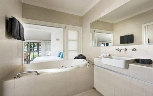布鲁姆红树林酒店的带浴缸、水槽和床的浴室