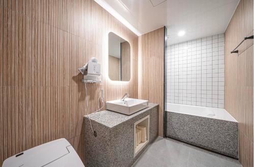 安东市Brown Dot Hotel Andong Ok-dong的浴室配有盥洗盆、卫生间和浴缸。