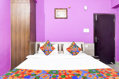 兰奇FabHotel Star Lotus的一间卧室设有紫色的墙壁和一张带两个枕头的床
