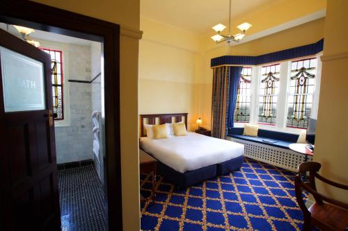 肯图巴卡林顿酒店的一间卧室设有一张床、一台电视和窗户。