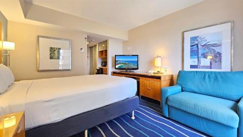 檀香山Ocean View Room at a resort的酒店客房,配有床和蓝色的沙发