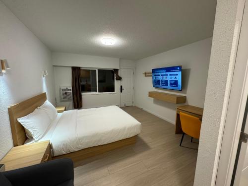霍普因唐尼汽车旅馆的一间卧室配有一张床、一张书桌和一台电视