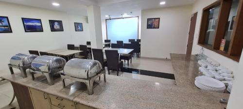 新德里Hotel Divine Admire Opp Gurudwara Sahib in Taimoor Nagar-Friends Colony的厨房设有带桌椅的用餐室