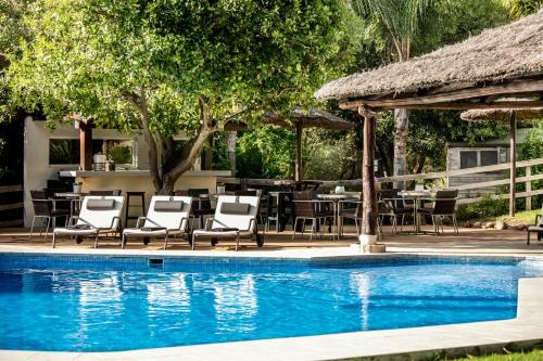 卡萨雷斯Villa Bermeja的游泳池配有桌椅和桌椅