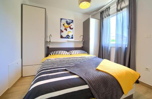 克尔克Apartment SARA的一间卧室配有一张大床,铺有黄色和灰色的床单