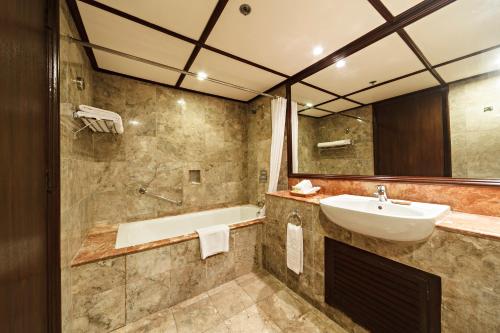 麦克坦Waterfront Airport Hotel and Casino的浴室配有盥洗盆和浴缸。