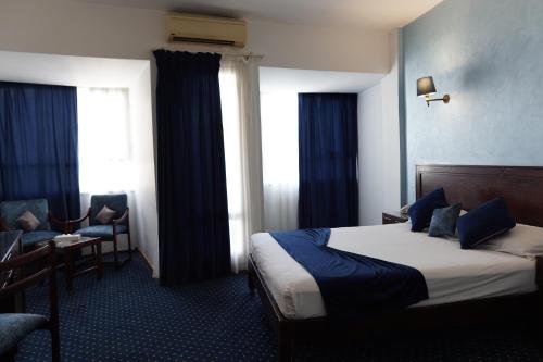 亚历山大Amon Alexandria的酒店的客房 - 带一张床、椅子和窗户