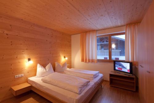 林格瑙Hotel Gasthof Wälderhof的一间卧室配有一张床,里面配有电视
