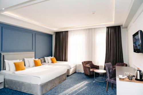 巴库Grand Hotel Baku Central Park的酒店客房带一张大床和椅子