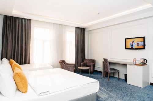 巴库Grand Hotel Baku Central Park的配有一张床和一张书桌的酒店客房