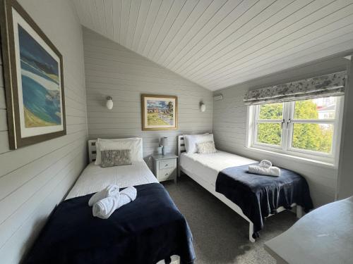 达尔比蒂Holly Blue - Cosy wooden lodge Kippford的一间卧室设有两张床和窗户。