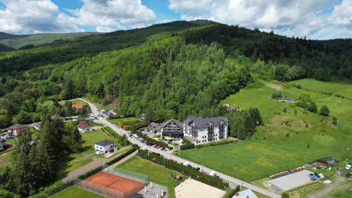 什切尔克Hotel Zimnik Luksus Natury Spa & Wellness的山中房屋的空中景观